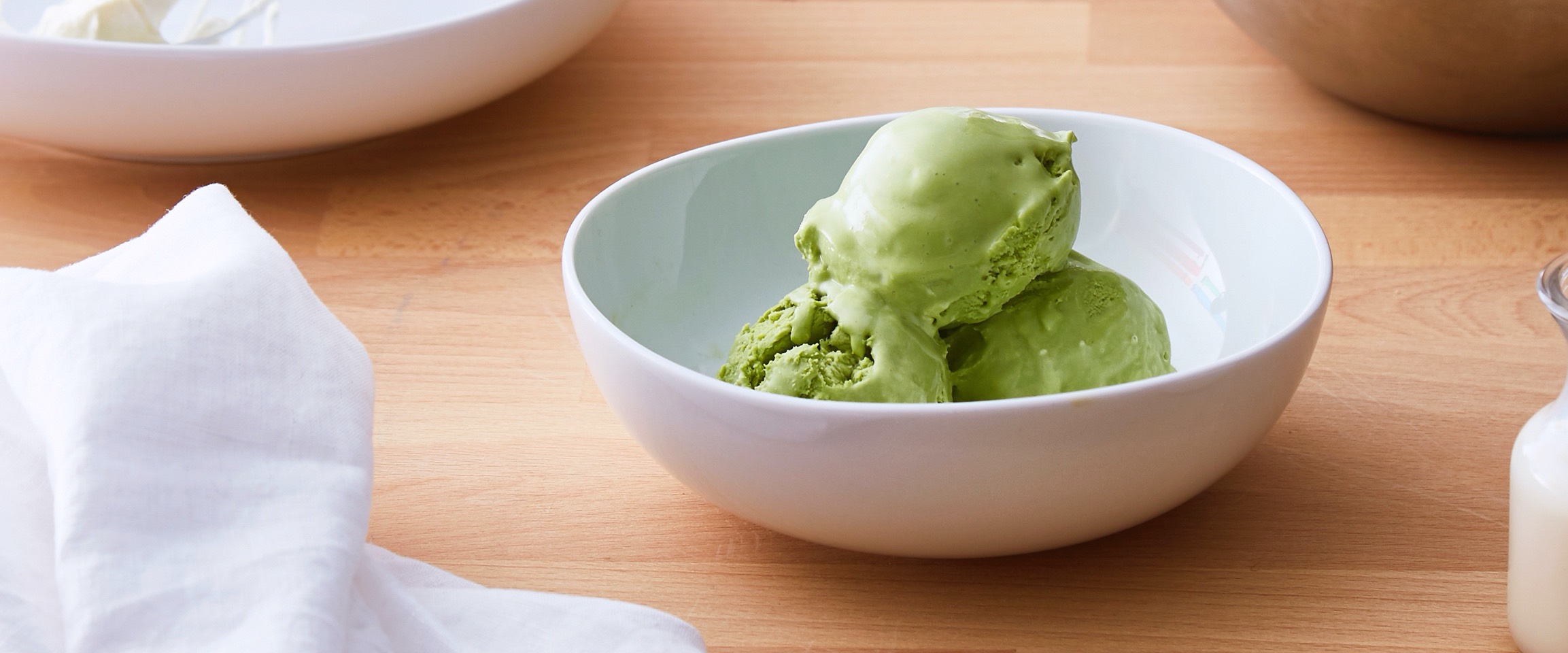Matcha ice cream in a white bowl.
