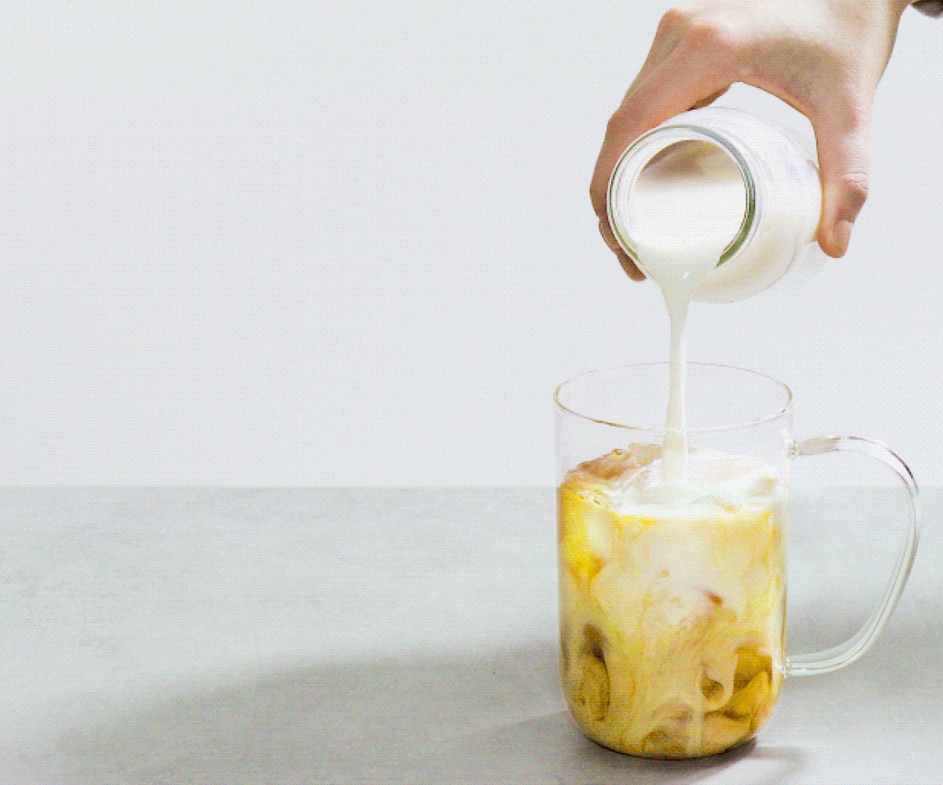 A Nordic mug filled with iced tea latte.