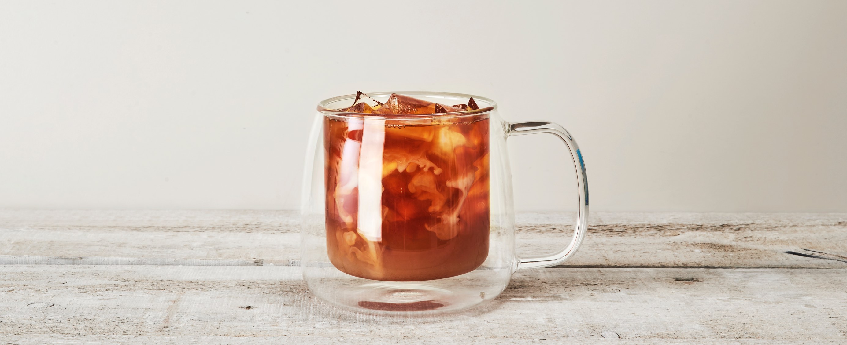 Clear 18 oz double walled glass latte mug filled with chai iced tea.