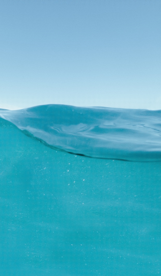 Une vague d’eau sous un ciel bleu.